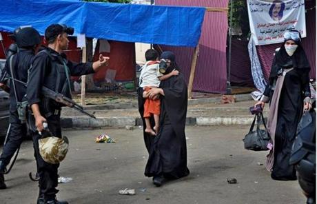 An Egyptian security force member escorted a woman with a child as the forces cleared a sit-in camp.
